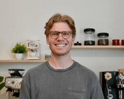 Noah smiling in front of his home espresso setup